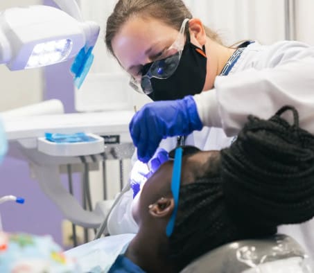 A Centura College dental assistant program student practicing teeth cleaning on another student